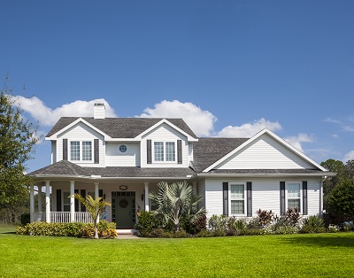 Traditional American home with space for copy; blue sky, extensive front lawn.