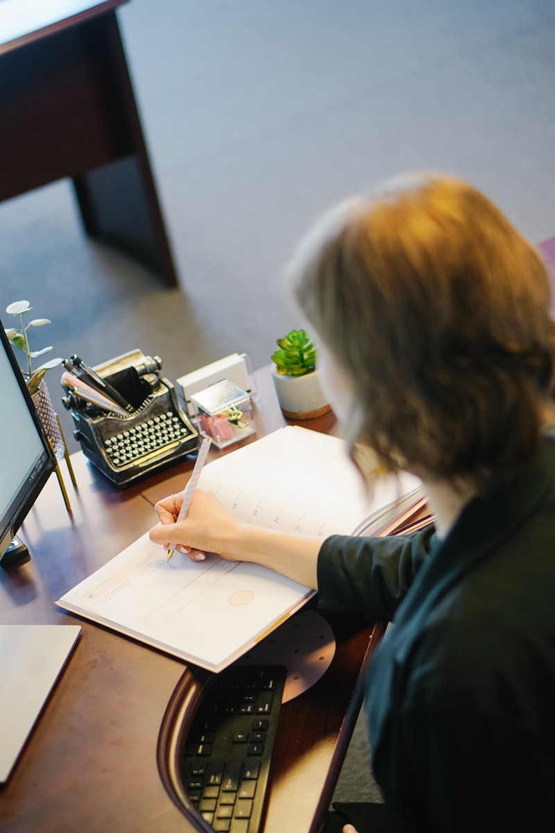 woman in black shirt sitting on chair writing on a document stating the Importance of Being the First-named Insured on an Insurance Policy